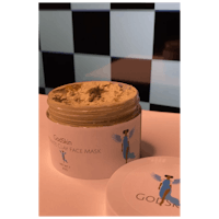 a jar of face mask sitting on a checkered table