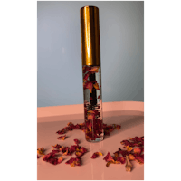 a bottle with rose petals on top of it